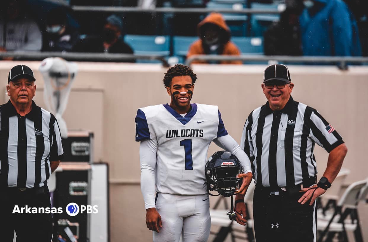 Two NWAFOA officials share a laugh with a player on the sideline